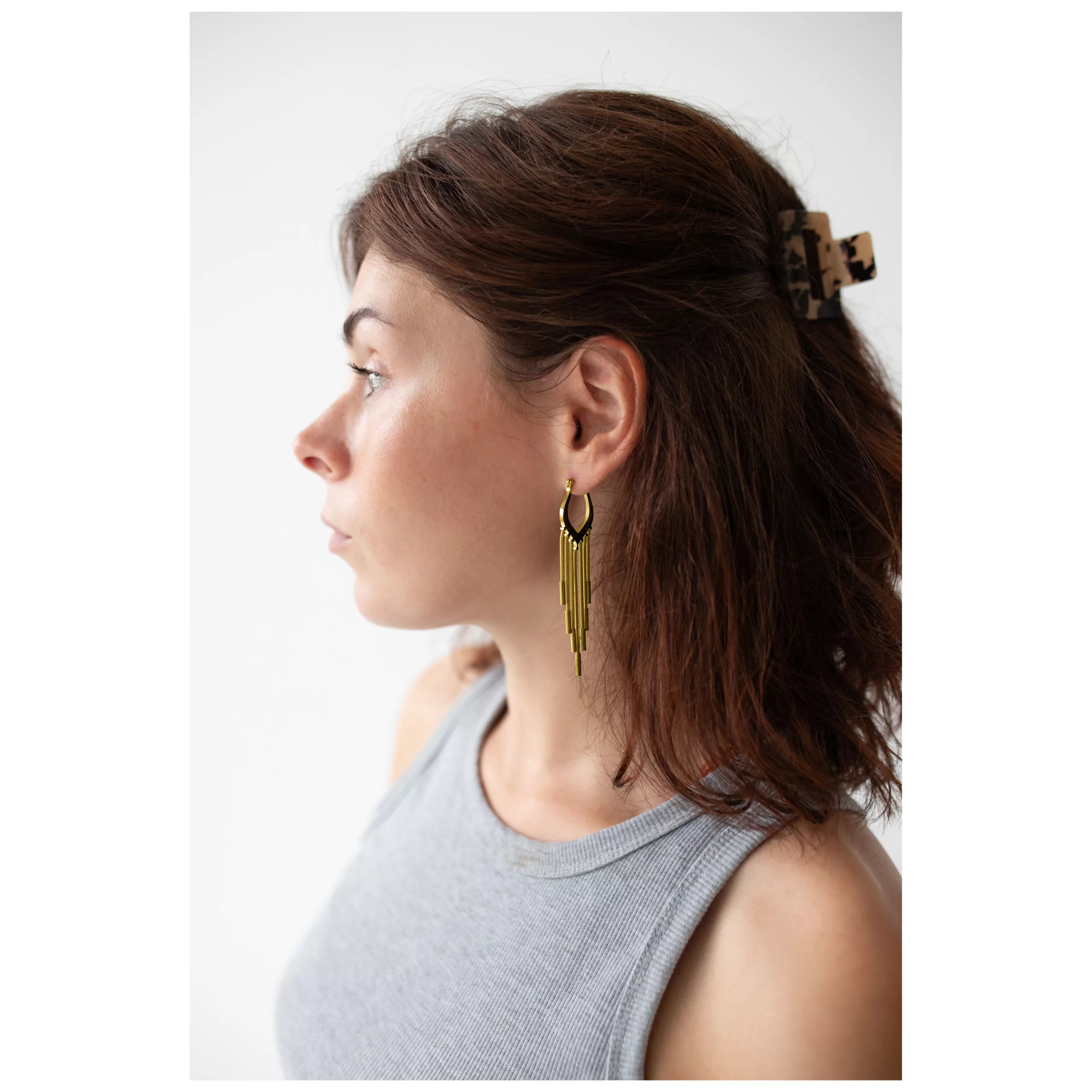 Orecchini a cerchio Snakechain dorati in profilo Donna con orecchini a cerchio Snakechain dorati su sfondo bianco