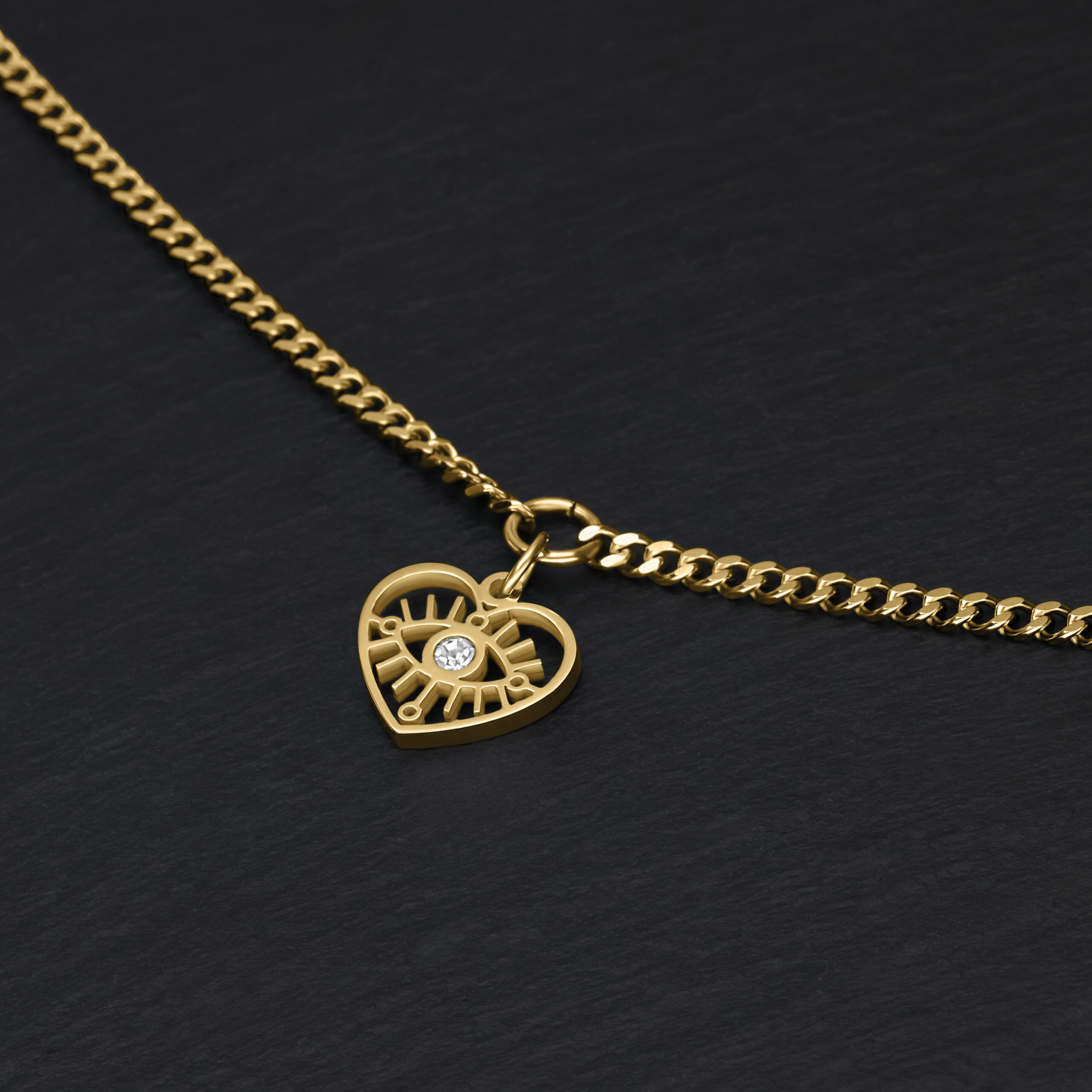 Goldenes Armband mit Herzanhänger auf schwarzem Hintergrund