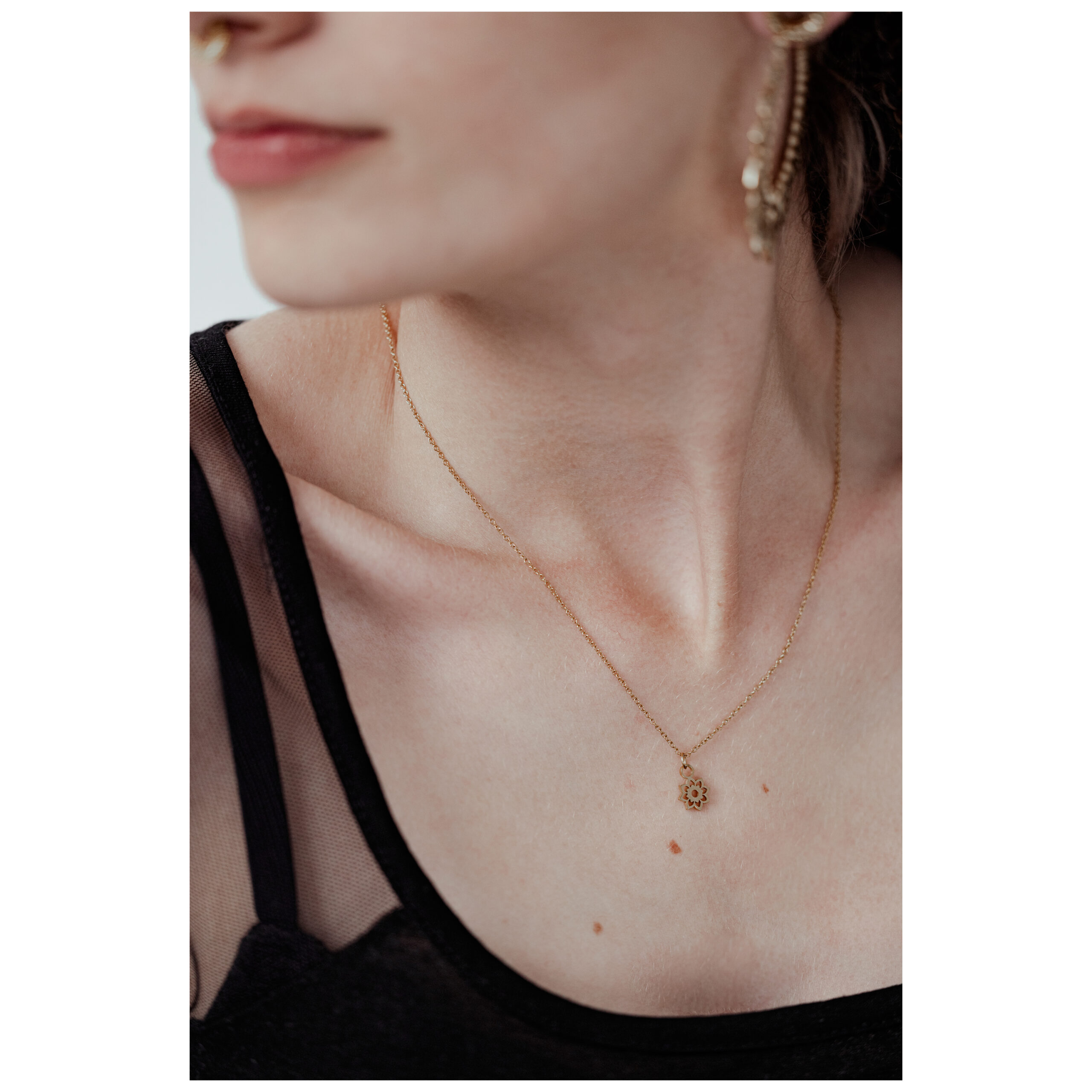 Collana Little Sunflower dorata sul collo di una persona su sfondo neutro