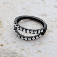 Clicker in titanio nero con doppia fila di cristalli su sfondo chiaro