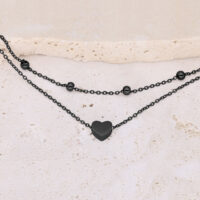 Bracciale nero con ciondolo a cuore su pietra chiara