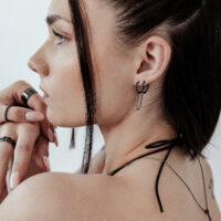 Donna con orecchini Double Huggie neri e capelli corti