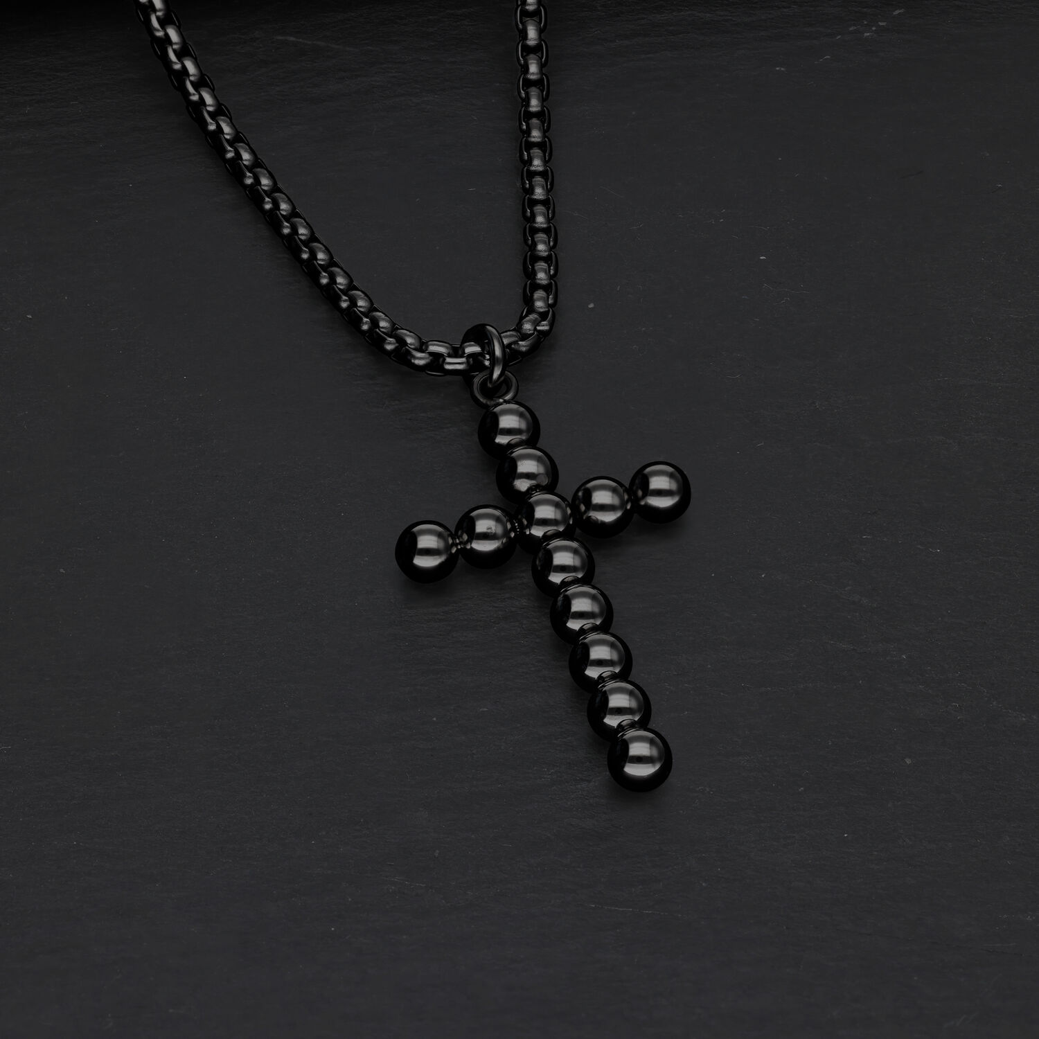 Collana a croce nera con design a bolle su sfondo scuro