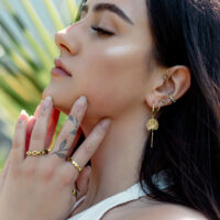 Frau trägt goldene Little Petticoat Hoops mit weiteren goldenen Accessoires