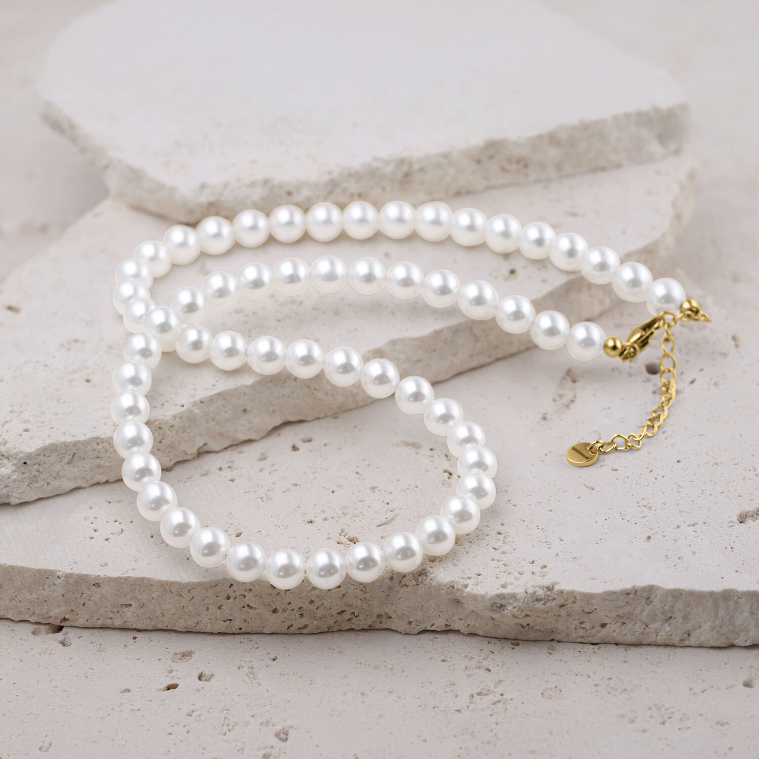 Große synthetische Perlenkette in Silber mit goldfarbenem Verschluss auf hellem Hintergrund
