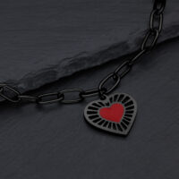 Bracciale nero con ciondolo a cuore rosso su sfondo scuro