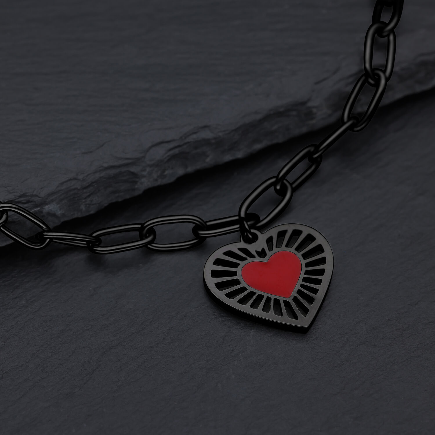 Bracciale nero con ciondolo a cuore rosso su sfondo scuro