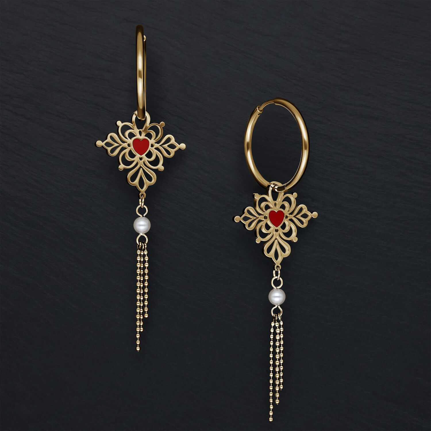 Goldene Creolen mit rotem Herzanhänger und Perlendetails vor schwarzem Hintergrund