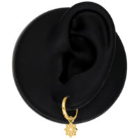 Goldene Mini Flower Hoops Ohrringe an schwarzem Modell-Ohr