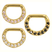 Drei goldene Septum Clicker mit schwarzen und klaren Kristallen auf weißem Hintergrund