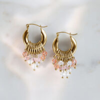 Goldene Glamour Hoops Ohrringe mit rosa und klaren Kristallen auf Marmorhintergrund