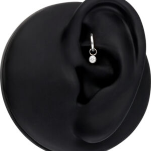 Silberner runder Kristall-Anhänger in einem schwarzen Modell-Ohr