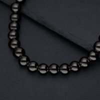 Collana Bubble nera lucida su sfondo di ardesia scura