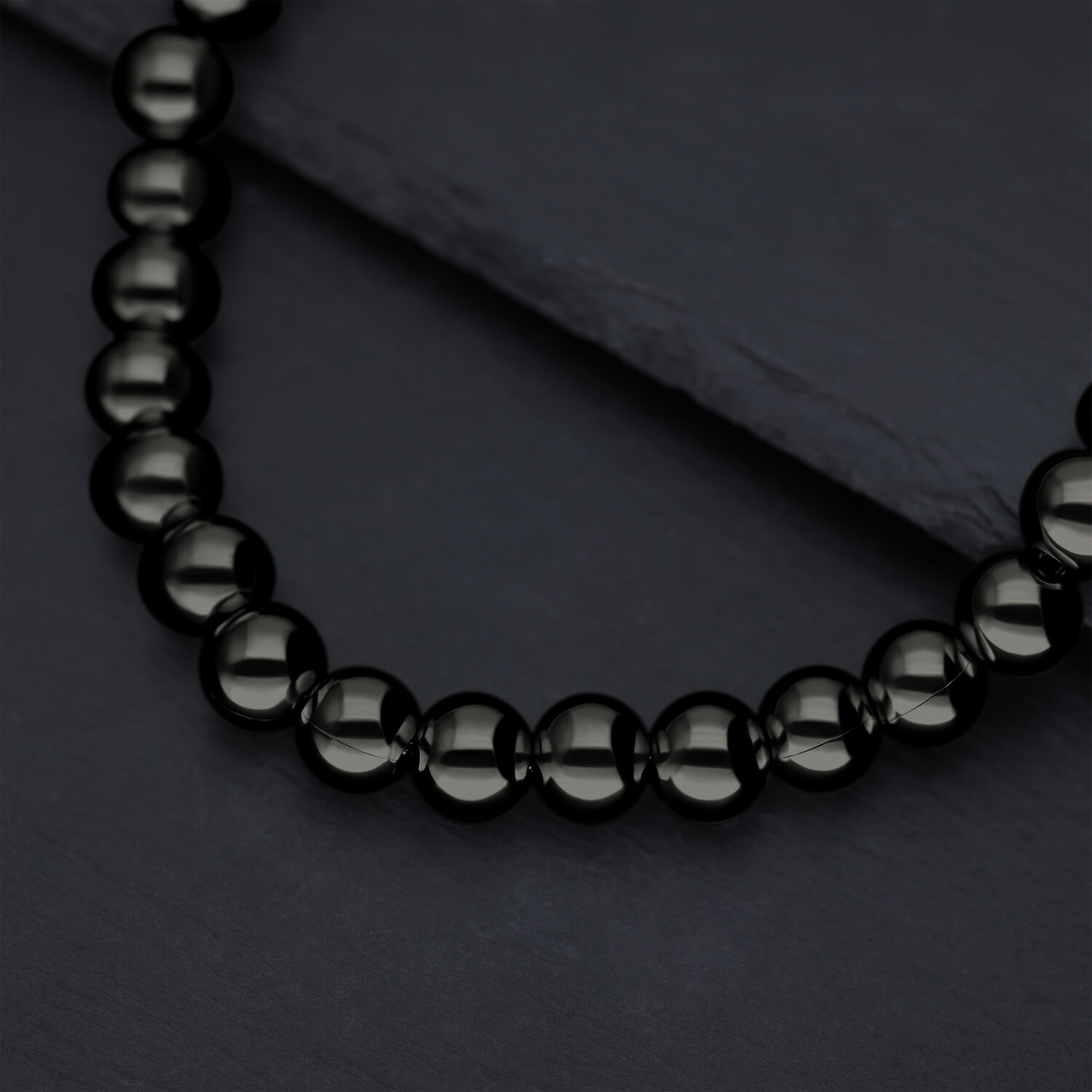 Collana Bubble nera lucida su sfondo di ardesia scura