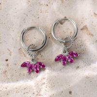 Orecchini d'argento con pendenti di cristallo rosa su superficie di pietra chiara