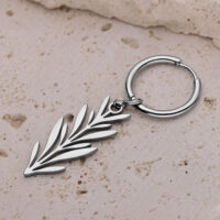 Orecchino d'argento con design a ramo su superficie di pietra beige