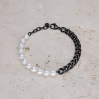 Bracciale con perline sintetiche bianche e catena nera su sfondo chiaro