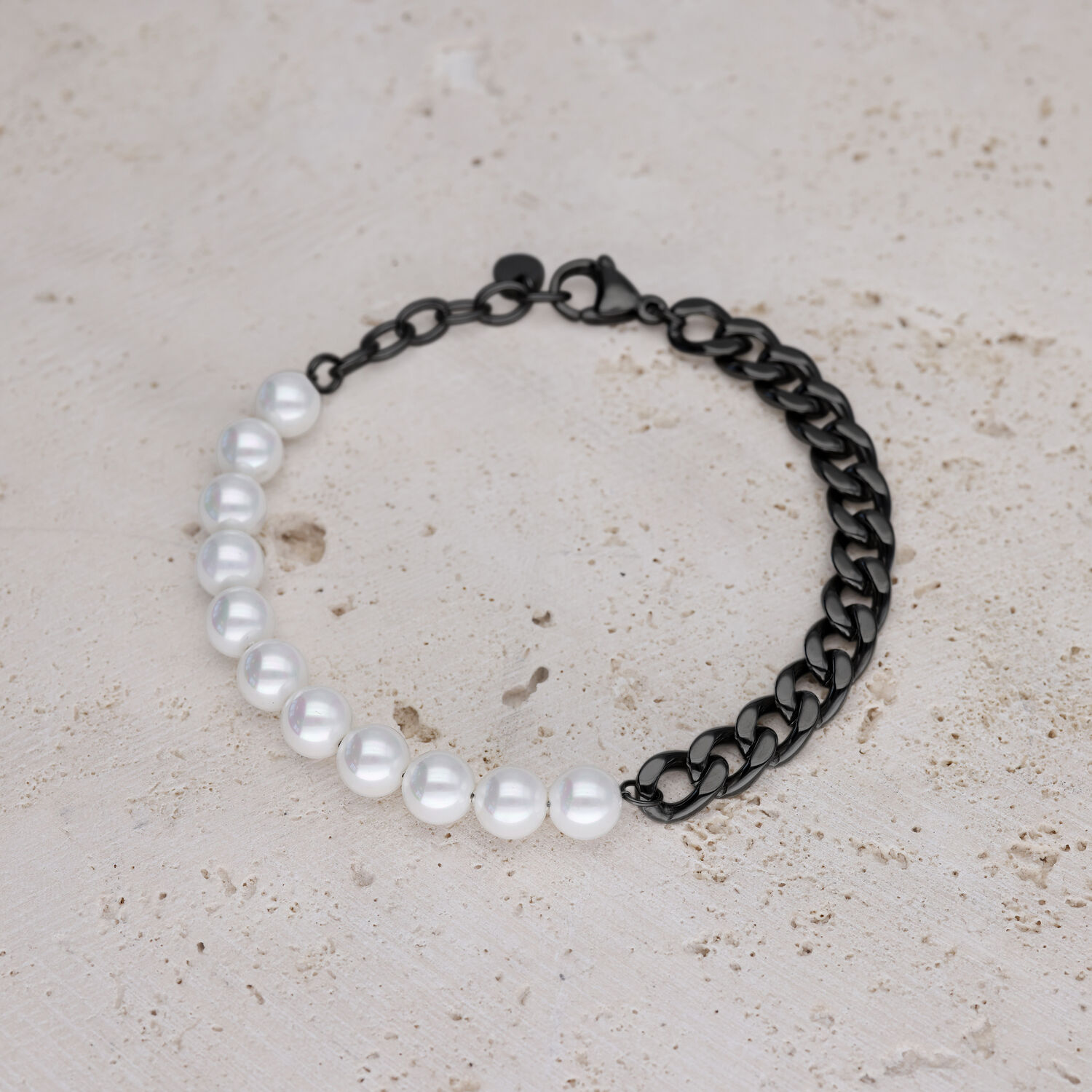 Bracciale con perline sintetiche bianche e catena nera su sfondo chiaro